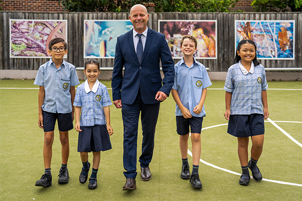 Principal Mr. Marcel Arendse walking with students in the playground